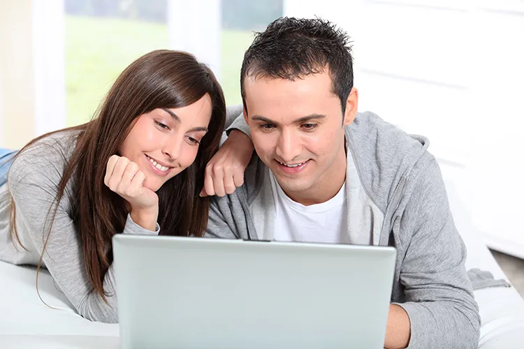 Hombre y mujer viendo opciones de seguros en un computador