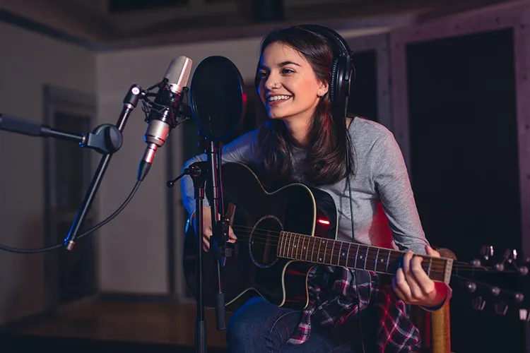 Mujer cantando y tocando guitarra