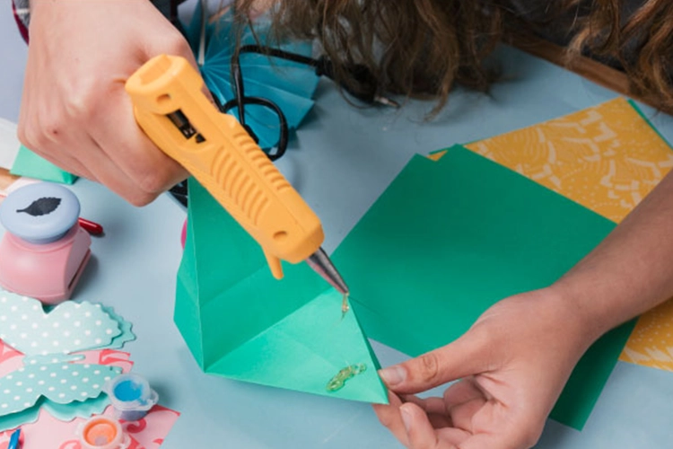 Persona pegando origami con silicona