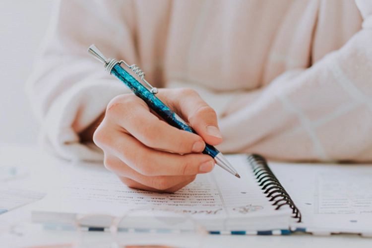 Persona escribiendo en un cuaderno