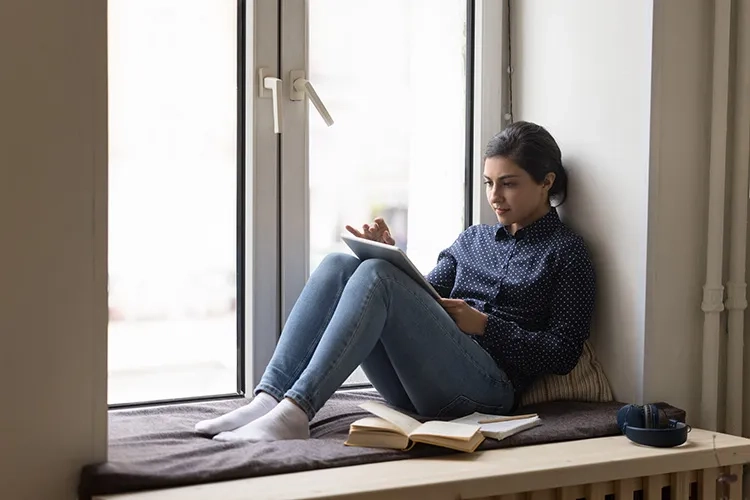 Mujer leyendo un libro desde su tablet.