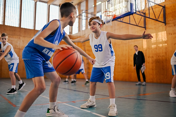 Dos jugadores adolescentes practican baloncesto