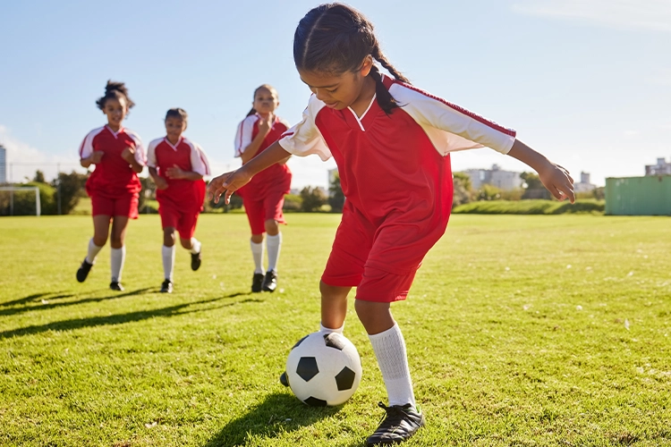 Niñas jugadoras de fútbol juegan un partido.