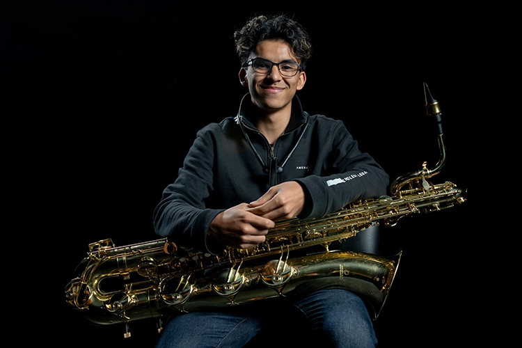 Hombre joven con un saxofón en sus manos.