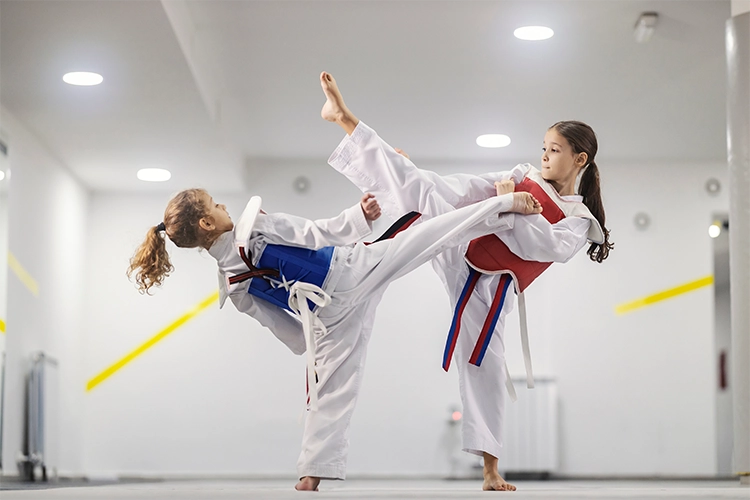 Dos niñas practican taekwondo.