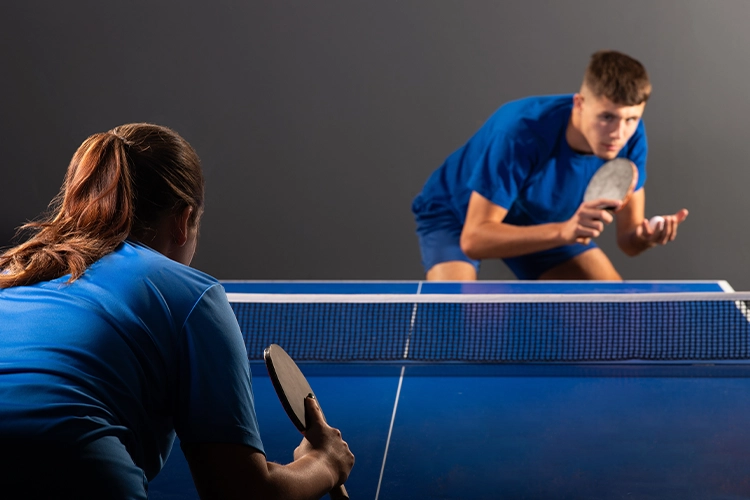 Dos jugadores de tenis de mesa concentrados en su partido.