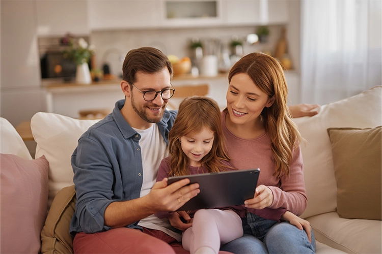 Familia leyendo un libro de la Biblioteca de Colsubsidio.