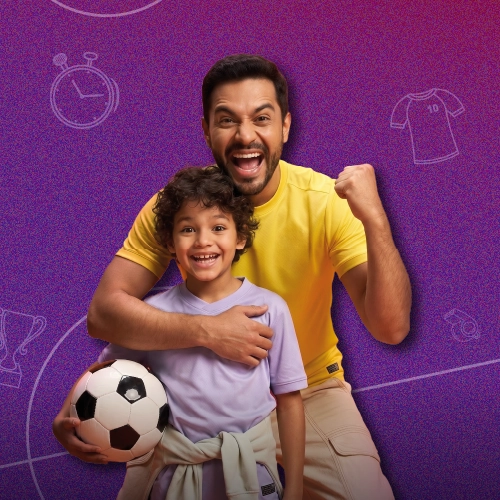 Papá e hijo sostienen pelota de fútbol