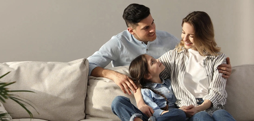 Familia sonríe en la sala de su casa