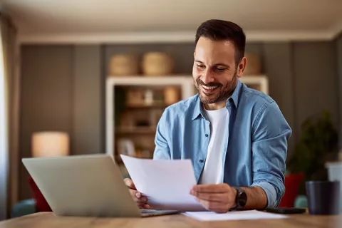 Hombre sonriendo viendo documentos