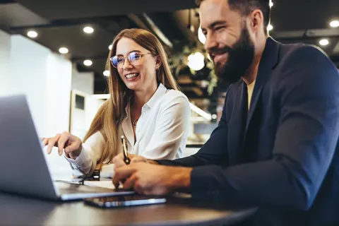 Hombre y mujer viendo en computador canales de atención