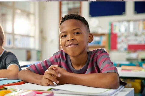 Niño estudiando y sonriendo